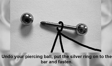Piercing bar with removable ball showing how a silver nipple chain attaches